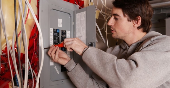 man adjusting electrical panel